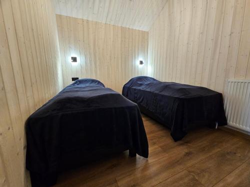 two beds in a room with wooden floors at Úthlíd Cottages in Úthlid