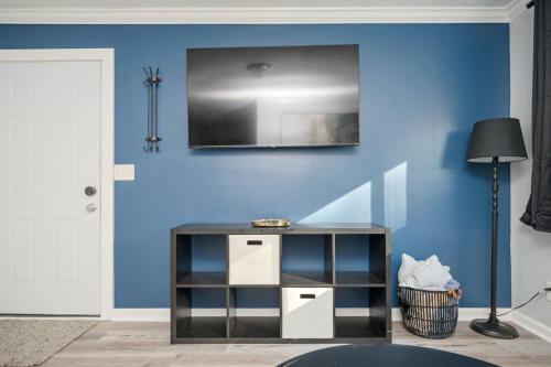 a living room with a blue wall and a table at Quiet & Quaint apartment, 5 mins to airport and 15 mins to downtown in Atlanta