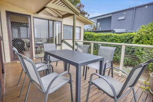 a patio with a table and chairs on a deck at 27 Kanangra Street Pambula Beach in Pambula Beach