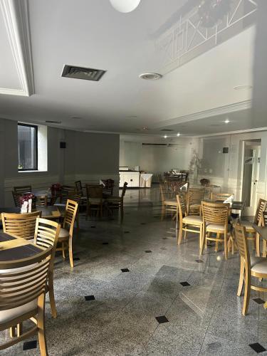 a dining room with wooden tables and chairs at Hotel Biena Sena Madureira PqIbirapuera Com Garagem 907 in Sao Paulo