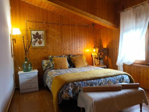 a bedroom with a bed in a wooden wall at Encanto en el Moncayo in San Martín de Moncayo