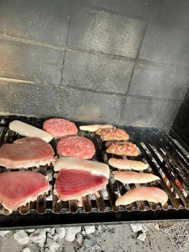 a grill with different types of meat on it at Descanso del GUERRERO in San Miguel de Fluviá