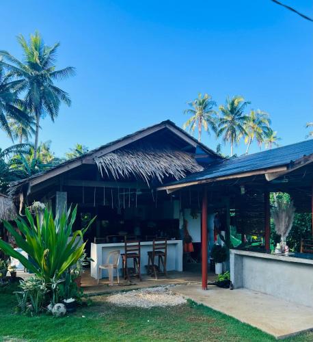 a house with tables and chairs and palm trees at Lone Traveler Beach View Room in Caridad