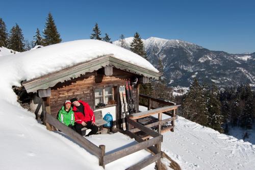 two people sitting in a cabin in the snow at Hotel Garni Berghof in Pertisau
