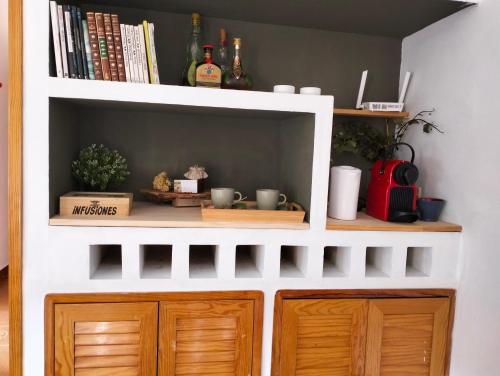 a white shelf with wooden cabinets and books at Encanto en el Moncayo in San Martín de Moncayo