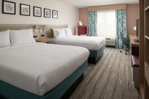 a hotel room with two beds and a desk at Hilton Garden Inn Tacoma Downtown in Tacoma