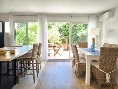 une salle à manger avec une table et des chaises blanches dans l'établissement Le Ptit Paradis d'Emma - Grand T3, Parking, Terrasse, à Cassis