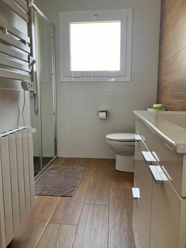a bathroom with a toilet and a sink and a window at Descanso del GUERRERO in San Miguel de Fluviá