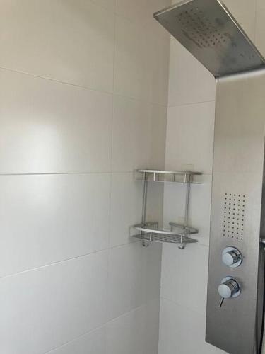 a shower in a bathroom with a white wall at Descanso del GUERRERO in San Miguel de Fluviá