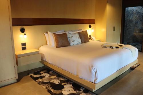 a bedroom with a large bed with white sheets and pillows at Parra del Valle Hotel Boutique in Valle de Guadalupe