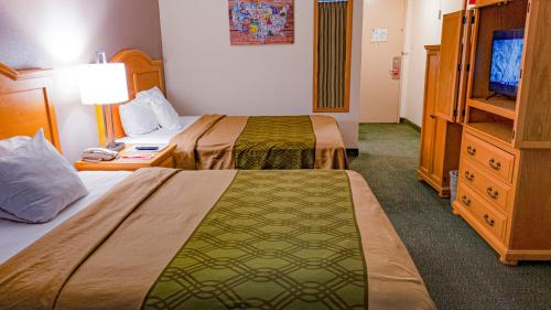 a hotel room with two beds and a television at Econo Lodge Rawlins in Rawlins