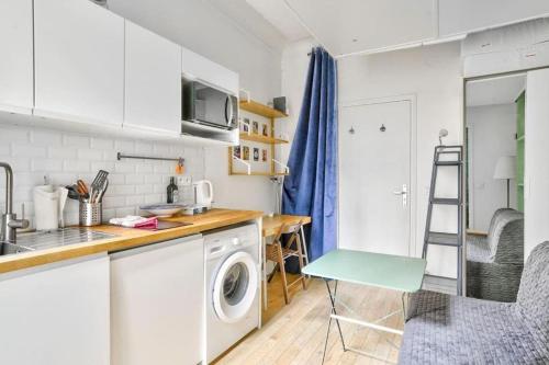 une cuisine avec une machine à laver et un évier dans l'établissement Cozy Nest - Montmartre Caulaincourt, à Paris