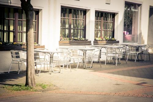 a group of tables and chairs in front of a building at Hotel Am Rathaus in Menden