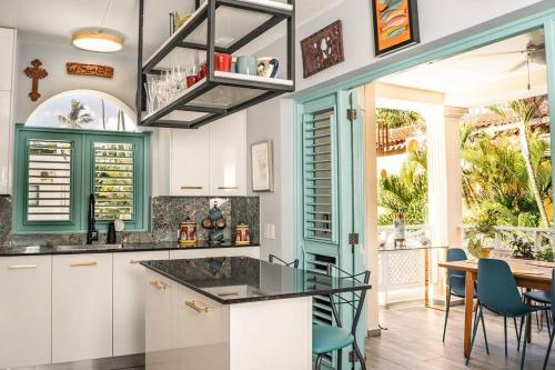 a kitchen with white cabinets and a table with chairs at Renovated Condo at the Beach Close to Everything in Las Terrenas