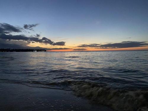 a sunset over a body of water with waves at Renovated Condo at the Beach Close to Everything in Las Terrenas