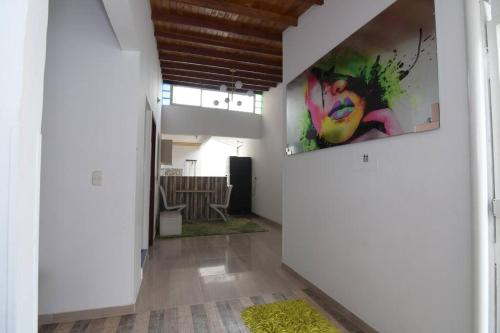 a hallway with white walls and a painting on the wall at luminoso y fresco apto cerca de todo in Girón