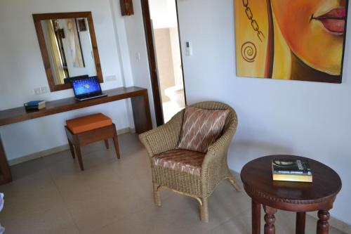 a living room with a chair and a table with a laptop at Lanka Beach Boutique Bungalows & Grand Villa in Tangalle
