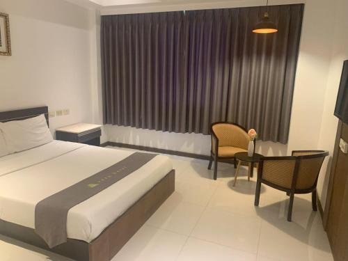 a hotel room with a bed and a table and chairs at Vera Hotel in Angeles