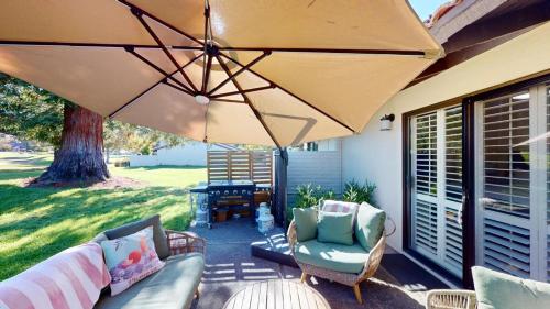 a patio with a couch and an umbrella at Silverado Golf Course View Property in Napa