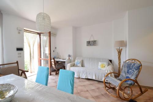 Una sala de estar con un sofá blanco y sillas azules. en Casa Gavina With Garden Alghero, en Fertilia