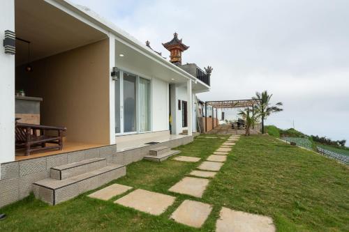 a house with a grass yard next to a building at Alam Nirwana in Gretek