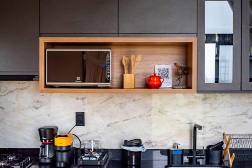a kitchen with a microwave and a counter top at Cabanas Purunã Ipê-Amarelo in Balsa Nova