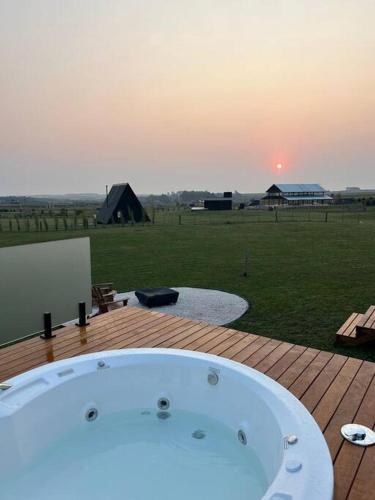 a bath tub sitting on a deck with a field at Cabanas Purunã Ipê-Amarelo in Balsa Nova
