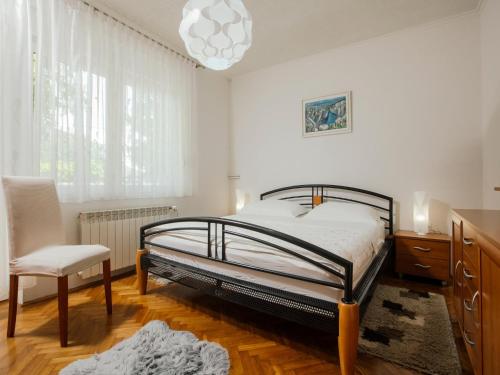 a bedroom with a bed and a chair and a chandelier at Villa in Croatia near Blue & Red Lakes in Imotski