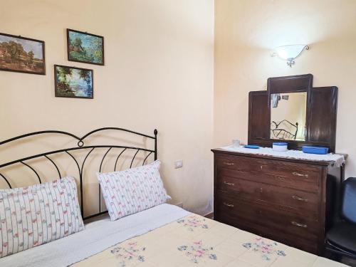 a bedroom with a bed and a dresser and a mirror at Apartment in Umbria near Montefalco Winery in Giano dellʼUmbria