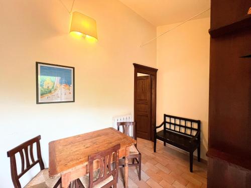 a dining room with a wooden table and a chair at Farmhouse in Giano dell'Umbria in Giano dellʼUmbria