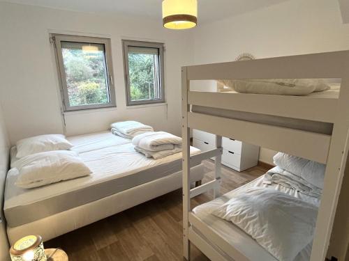 Cette chambre comprend 2 lits superposés et 2 fenêtres. dans l'établissement High end holiday home for 6 people, à Trébeurden