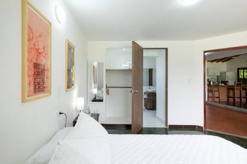 a bedroom with a white bed and a mirror at Hotel Chalet La Sofia by Majuva in Armenia