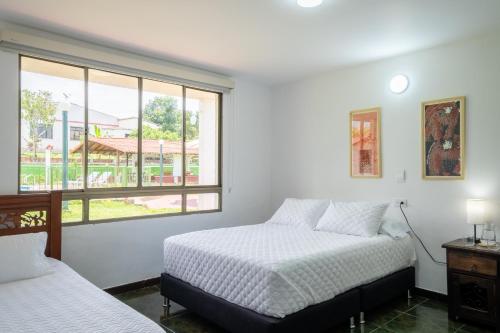 two beds in a room with a window at Hotel Chalet La Sofia by Majuva in Armenia