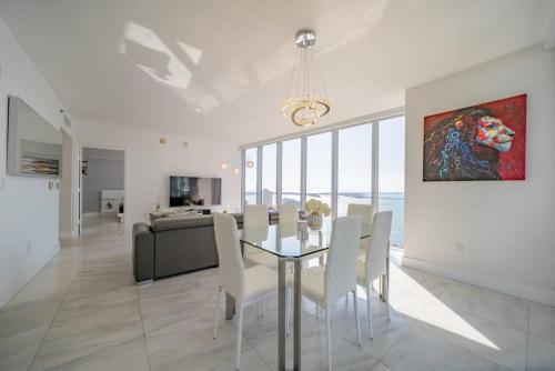 a dining room with a glass table and white chairs at Luxury Ocean View 2BR Corner Unit at W residence in Miami