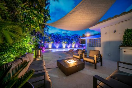 un patio trasero con sofás y una hoguera en New Luxury Villa Delilah Biscayne Park, en Biscayne Park