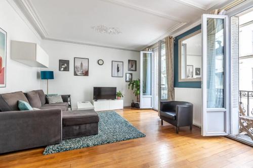 un salon avec un canapé et une télévision dans l'établissement Appartement cozy en plein cœur de Paris, à Paris