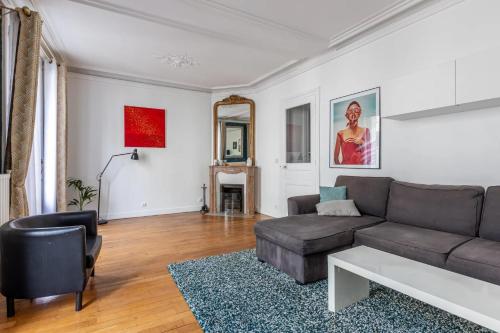 un salon avec un canapé et une table dans l'établissement Appartement cozy en plein cœur de Paris, à Paris