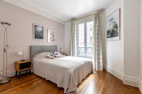 une chambre avec un lit avec un ours en peluche dessus dans l'établissement Appartement cozy en plein cœur de Paris, à Paris