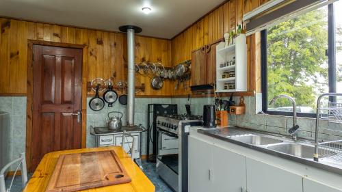 a kitchen with a sink and a stove at Maravillosa cabaña Panguipulli in Panguipulli