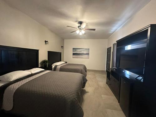 a bedroom with two beds and a ceiling fan at Playas Hotel Suites in Puerto Peñasco