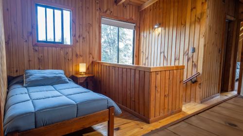 a bedroom with a bed in a wooden room at Maravillosa cabaña Panguipulli in Panguipulli