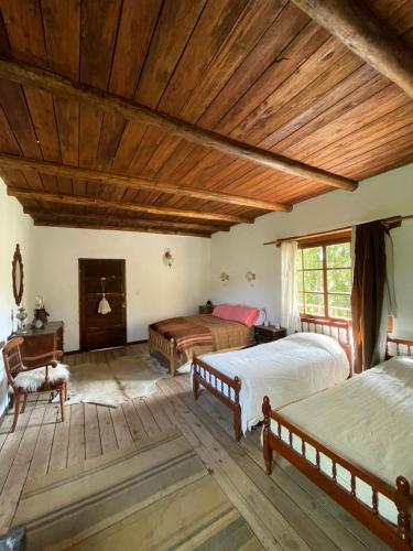 ein Schlafzimmer mit zwei Betten und einer Holzdecke in der Unterkunft Estancia Santa Thelma in Gobernador Gregores