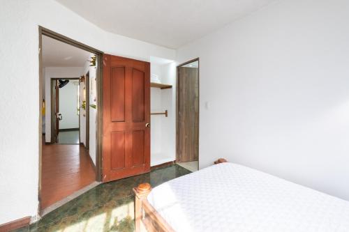 a bedroom with a bed and a wooden door at Hotel Chalet La Sofia by Majuva in Armenia