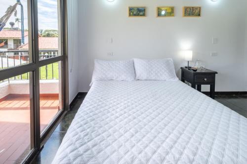 a white bed in a room with a window at Hotel Chalet La Sofia by Majuva in Armenia