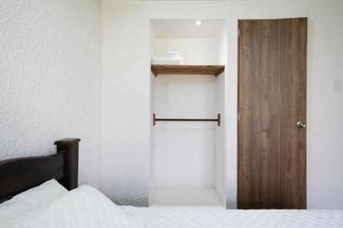 a bedroom with a bed and a wooden door at Hotel Chalet La Sofia by Majuva in Armenia