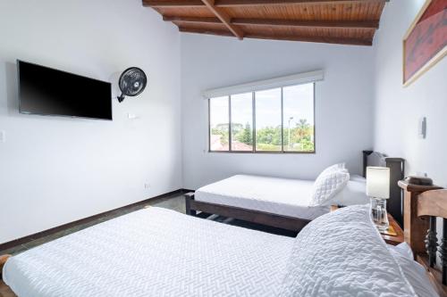 a bedroom with two beds and a flat screen tv at Hotel Chalet La Sofia by Majuva in Armenia