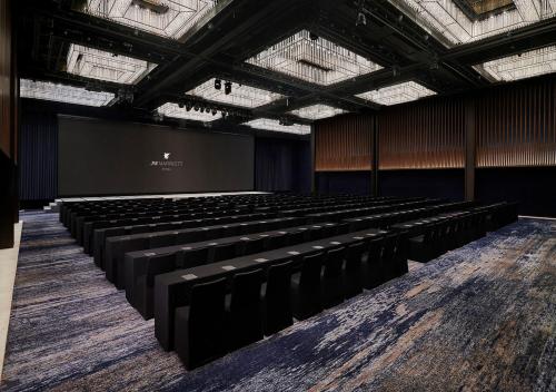 an empty auditorium with black chairs and a screen at JW Marriott Hotel Seoul in Seoul