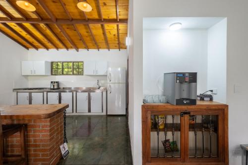 a kitchen with white walls and a wooden ceiling at Hotel Chalet La Sofia by Majuva in Armenia