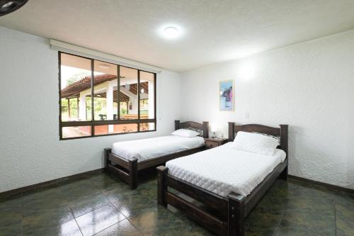 two beds in a room with a window at Hotel Chalet La Sofia by Majuva in Armenia