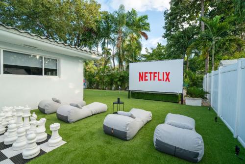 un césped con algunas sillas inflables y una señal en New Luxury Villa Delilah Biscayne Park, en Biscayne Park